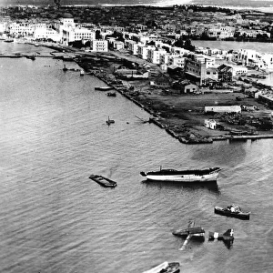 The photograph shows the shattered waterfront of the main supply port of Benghazi