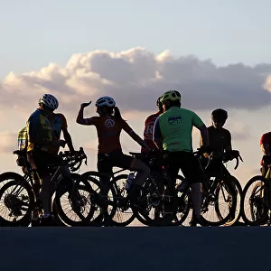 Group of cyclists silhouetted at sunset