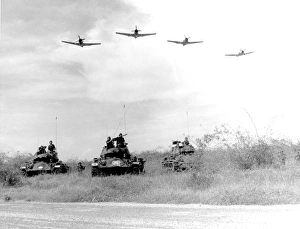 A-1H aircraft make a low level pass over Vietnamese tanks and ground troops A-1H aircraft make a low level pass over Vietnamese tanks and ground troops
